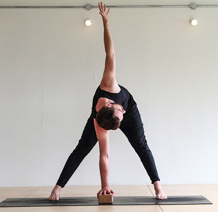 man doing easier Wide-legged Forward Bend yoga (Prasarita Padottanasana)