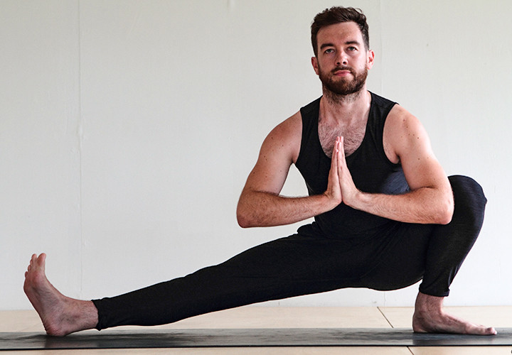Man doing yoga Side Ninja (Skandasana)