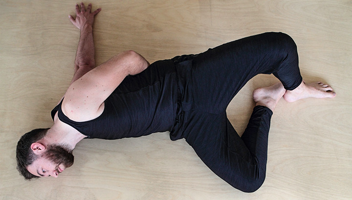 Man doing broken wing yoga pose